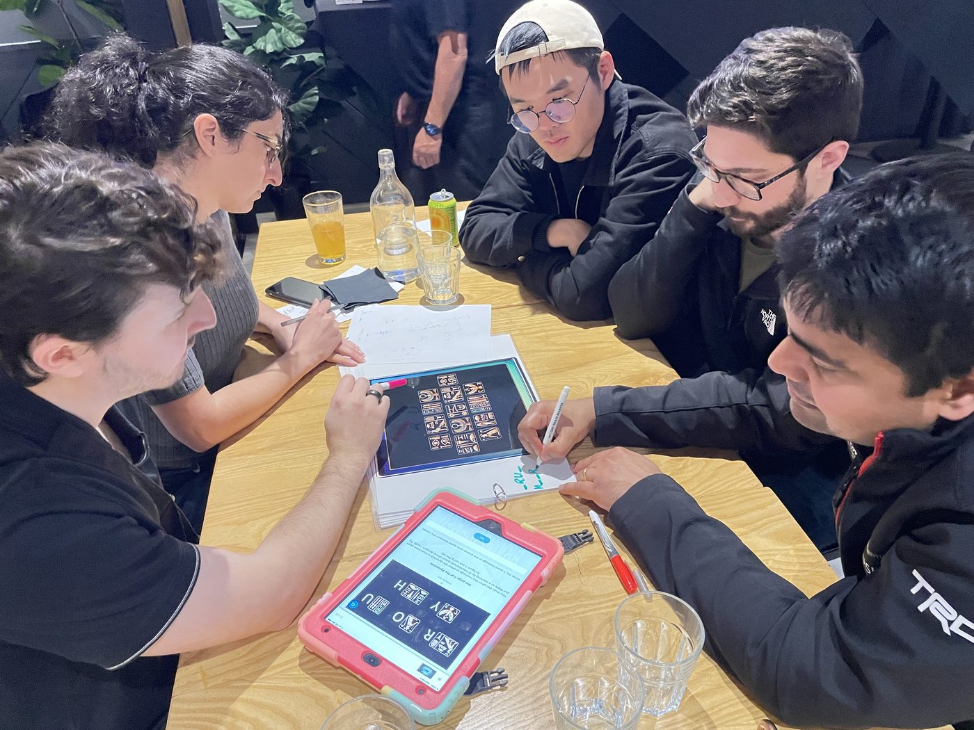 A team shares discoveries around a table of puzzles